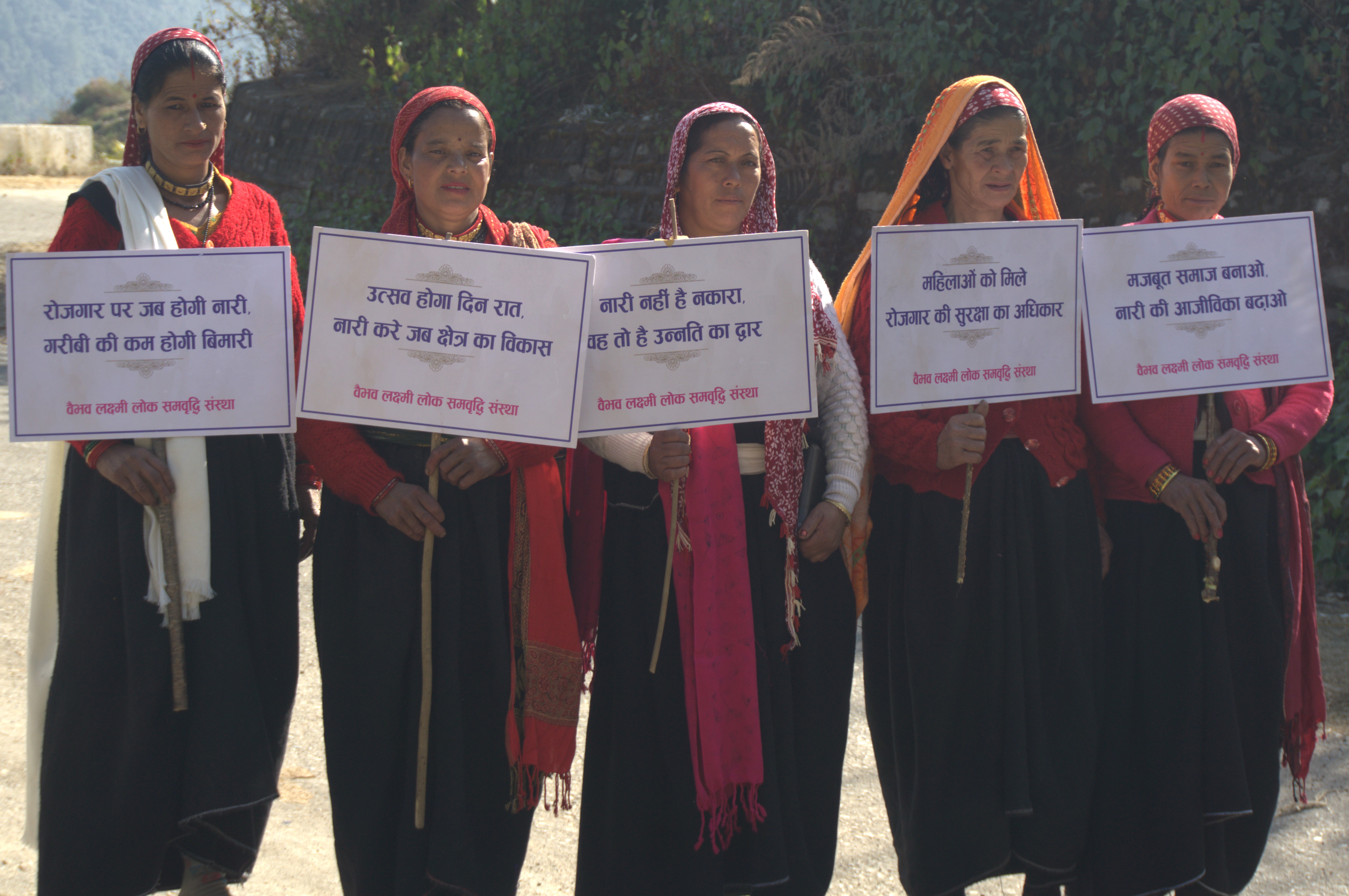 Women at Namtol display placards with messages about women’s participation and livelihoods.